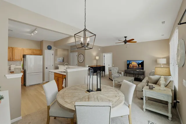 a living room with furniture a dining table and a chandelier