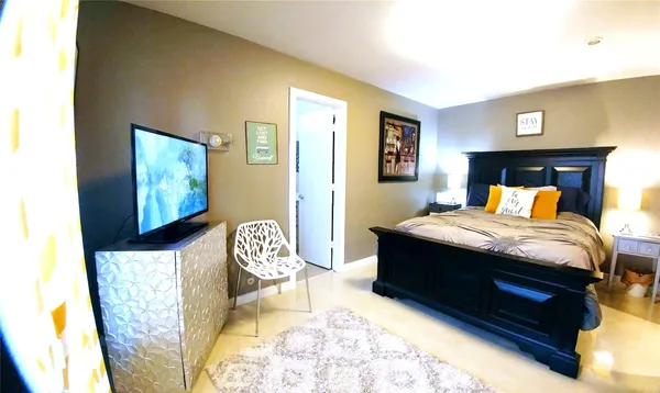 a bedroom with a bed chair and dresser