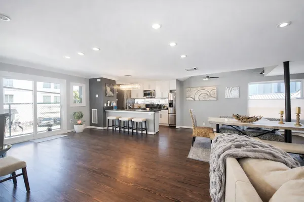 a living room with furniture and a table with wooden floor