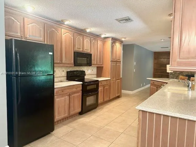 a kitchen with a refrigerator a sink and a stove top oven