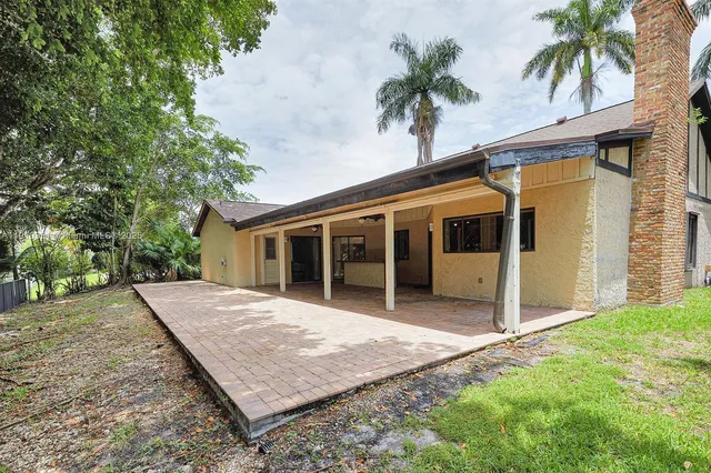 a view of a house with a yard and potted plants