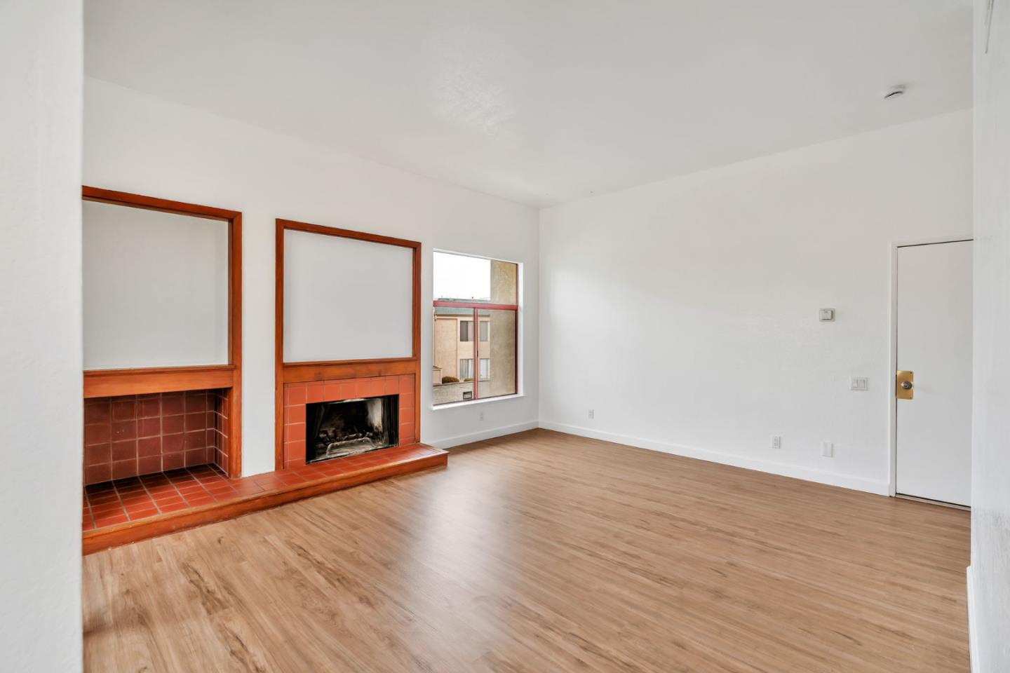 2416 North Main Street, Unit F Salinas, CA 93906 - Photo 6 of 39 wooden floor fireplace and windows in an empty room