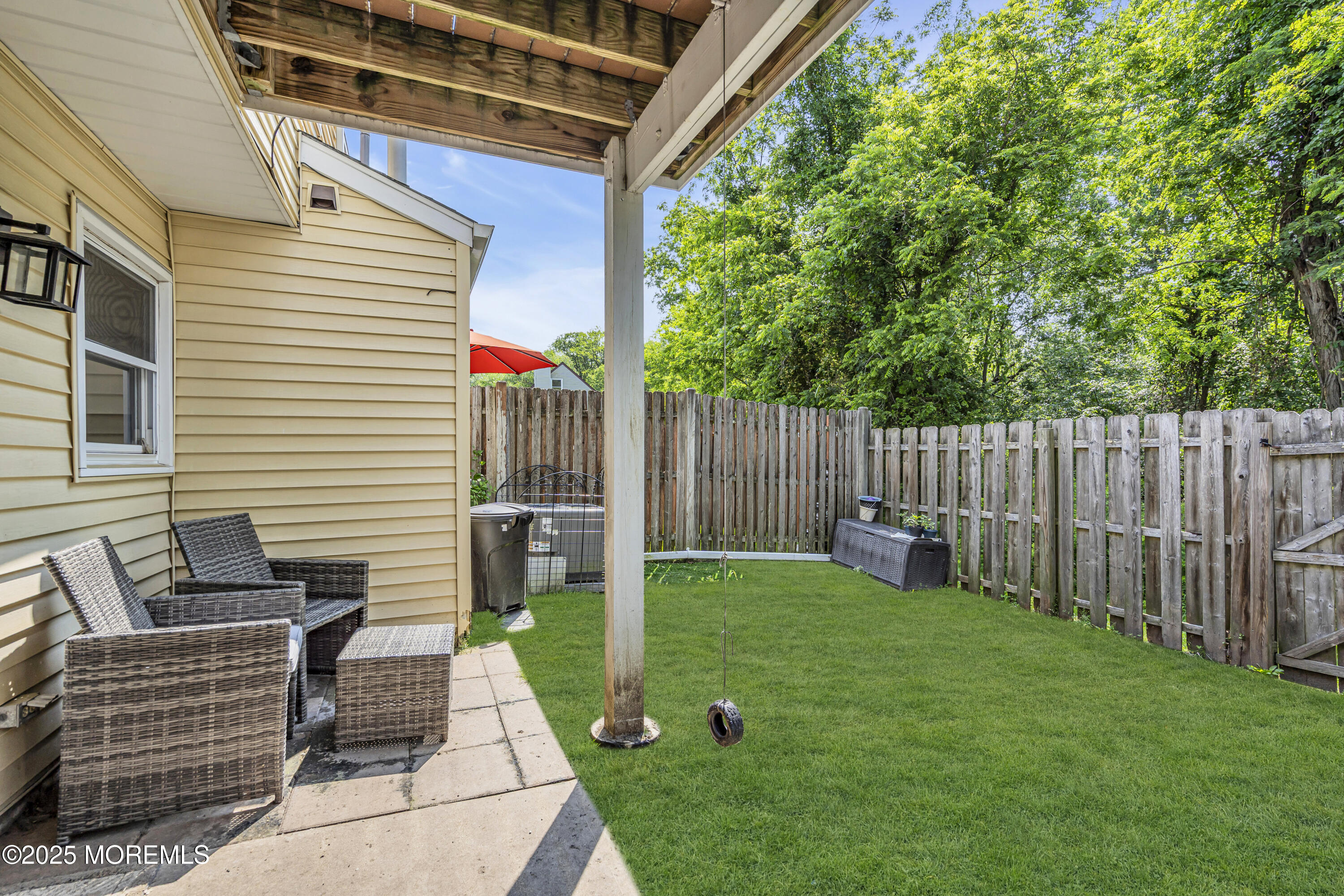39 Colonial Court Jackson, NJ 08527 - Photo 23 of 26 a view of backyard with wooden fence and a large tree