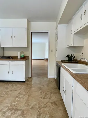 a kitchen with granite countertop a sink a stove and a refrigerator
