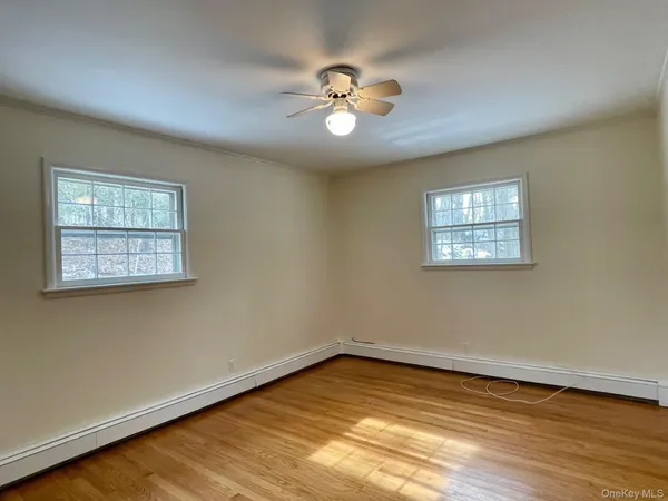 a view of a room with wooden floor and chandelier fan