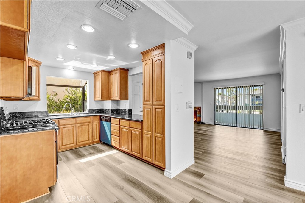 19620 Sherman Way, Unit 1 Reseda, CA 91335 - Photo 11 of 29 a kitchen with stainless steel appliances granite countertop a refrigerator a sink dishwasher a stove and white countertops with wooden floor