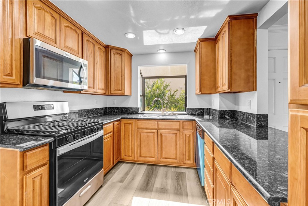 19620 Sherman Way, Unit 1 Reseda, CA 91335 - Photo 12 of 29 a kitchen with granite countertop cabinets stainless steel appliances a sink and a window