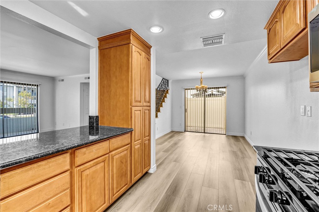 19620 Sherman Way, Unit 1 Reseda, CA 91335 - Photo 14 of 29 a hallway with stainless steel appliances granite countertop a sink and wooden floor