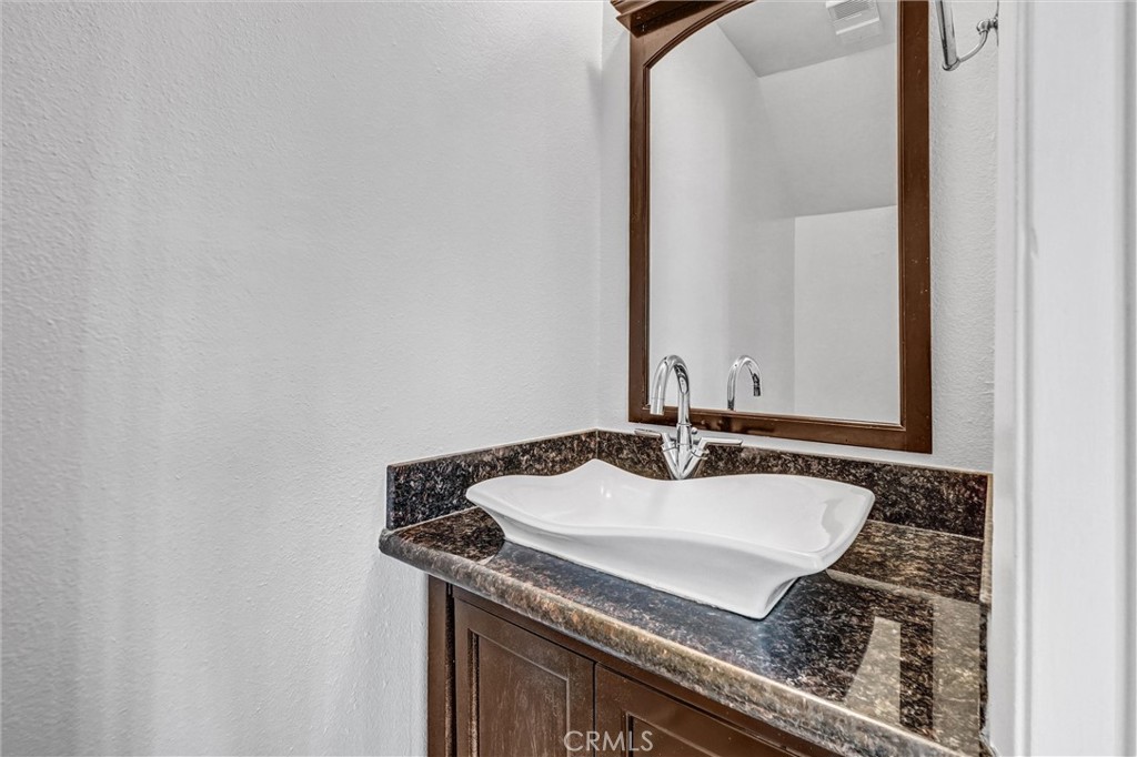 19620 Sherman Way, Unit 1 Reseda, CA 91335 - Photo 18 of 29 a bathroom with a granite countertop sink and a mirror