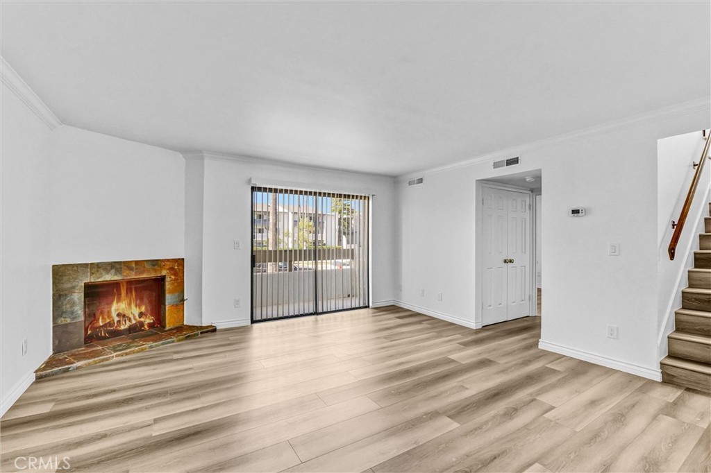 19620 Sherman Way, Unit 1 Reseda, CA 91335 - Photo 5 of 29 a view of empty room with wooden floor and fireplace