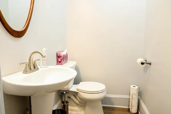 a bathroom with a toilet sink and mirror