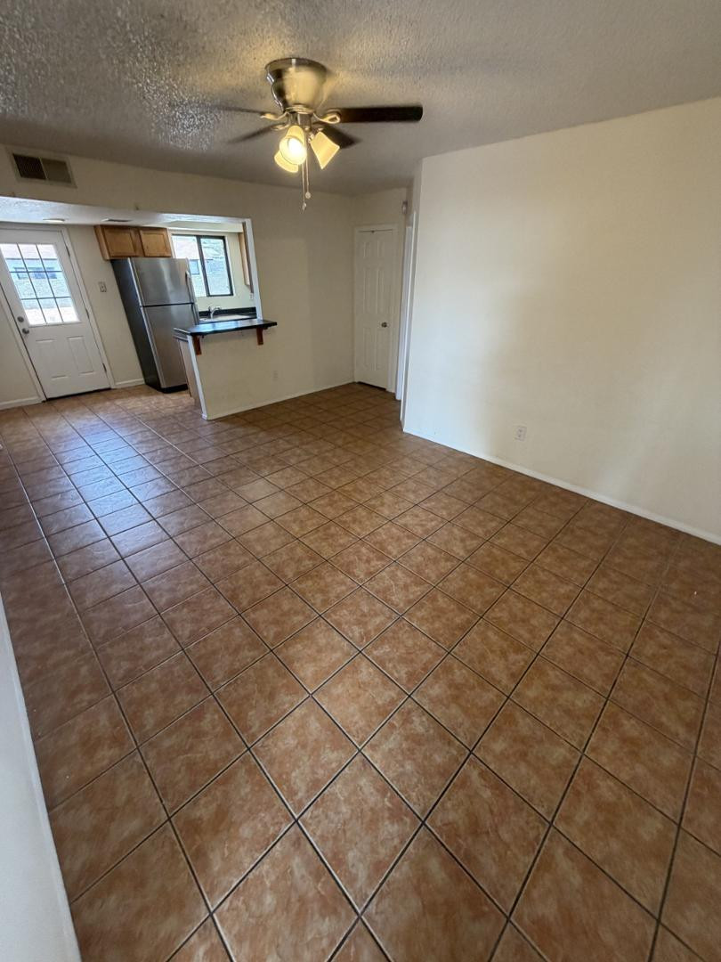 1336 East Mountain View Road, Unit 105 Phoenix, AZ 85020 - Photo 4 of 15 an empty room with windows and ceiling fan