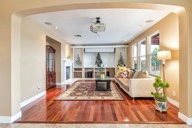 a kitchen with stainless steel appliances granite countertop a refrigerator a sink dishwasher a stove with wooden cabinets and floor