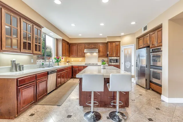 a living room with stainless steel appliances granite countertop a table and chairs