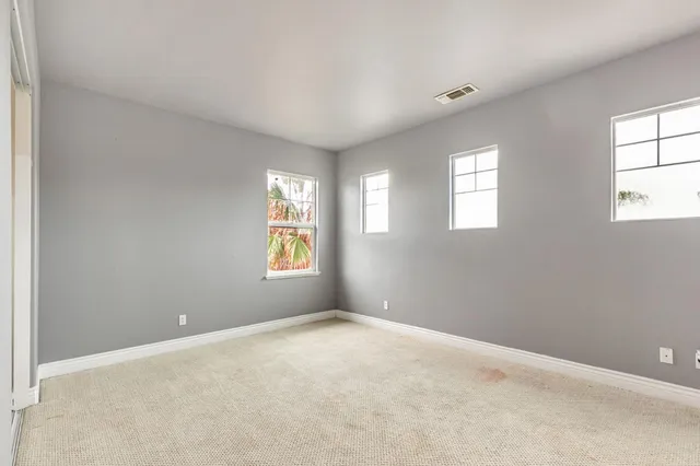 an empty room with windows and closet