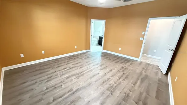 a view of an empty room with wooden floor