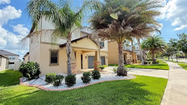 a front view of a house with a garden and trees
