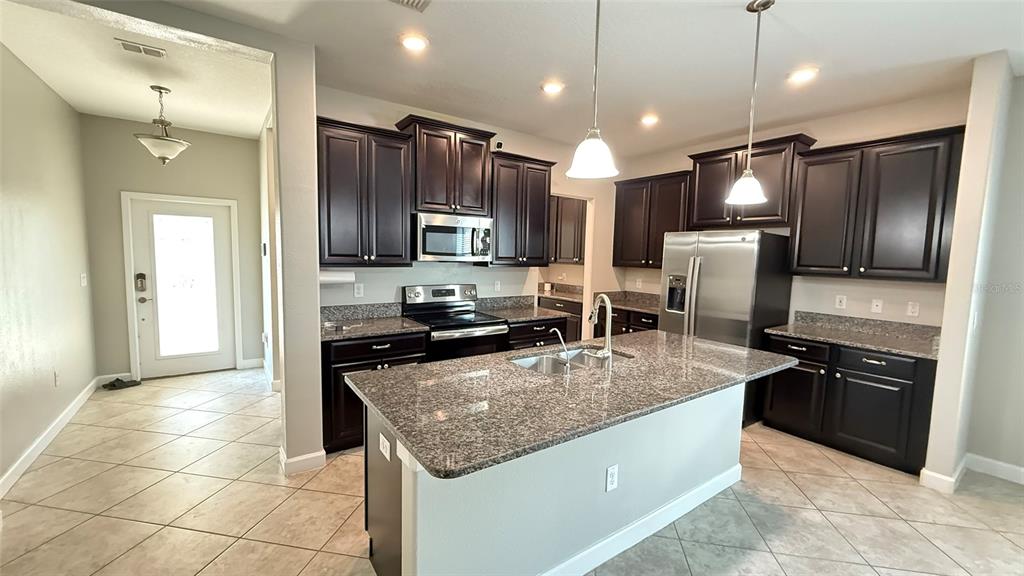 11017 Purple Martin Boulevard Riverview, FL 33579 - Photo 7 of 46 a kitchen with stainless steel appliances granite countertop a refrigerator a stove a sink and a microwave
