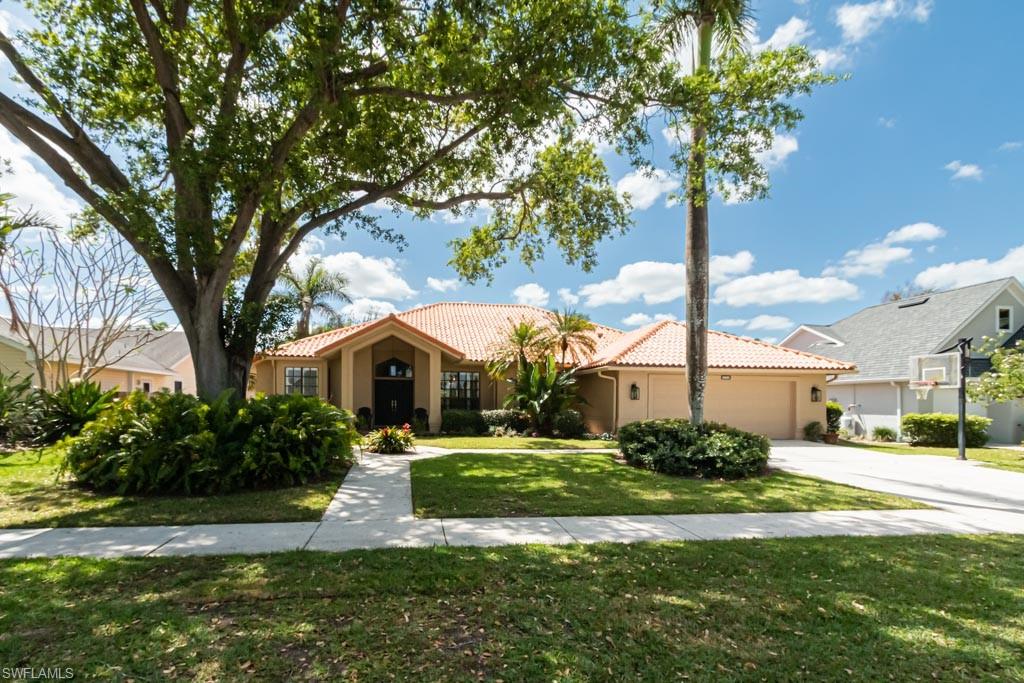 a front view of a house with a yard and palm trees