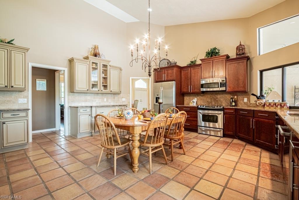 2209 Pinewoods Circle Naples, FL 34105 - Photo 12 of 46 a large kitchen with a table and chairs in it