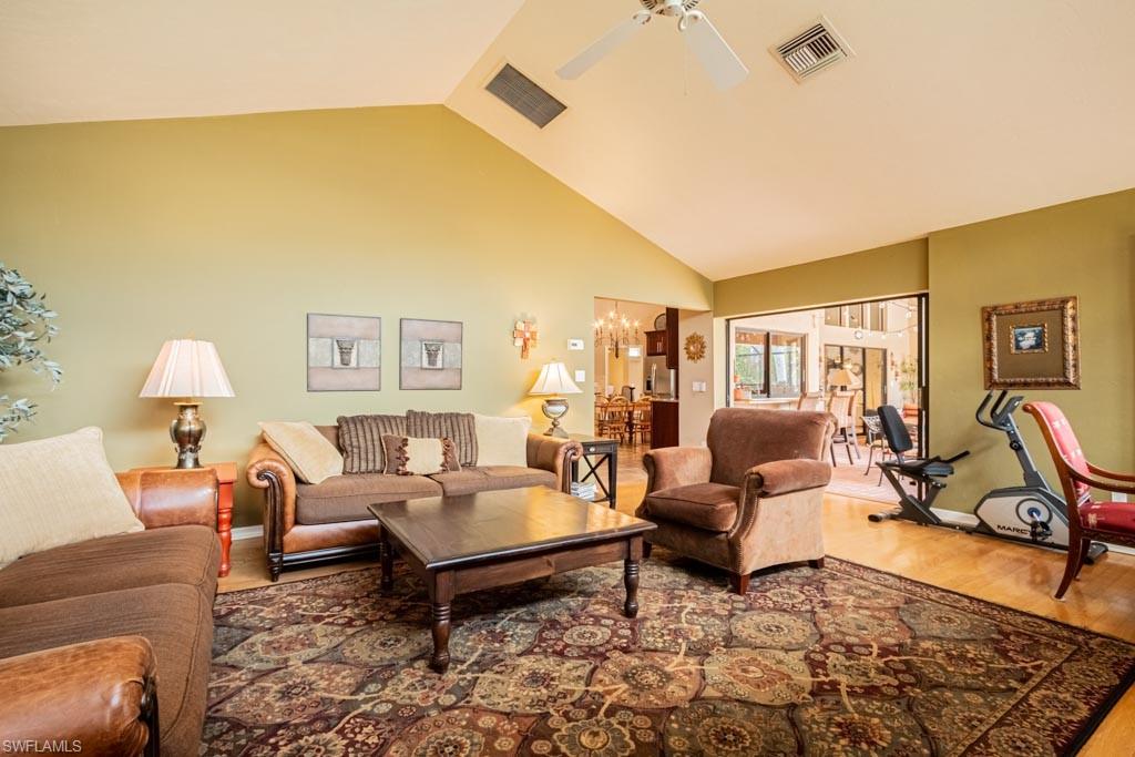 2209 Pinewoods Circle Naples, FL 34105 - Photo 17 of 46 a living room with furniture wooden floor and a lamp