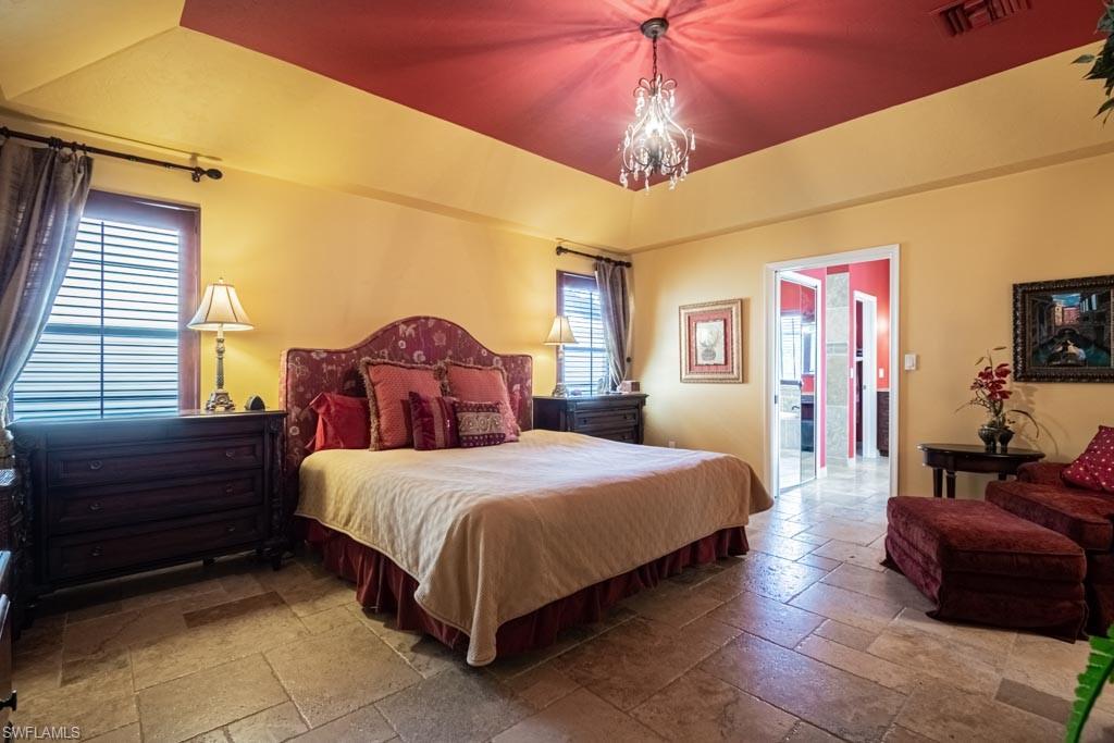 2209 Pinewoods Circle Naples, FL 34105 - Photo 18 of 46 a bedroom with a bed and a chandelier