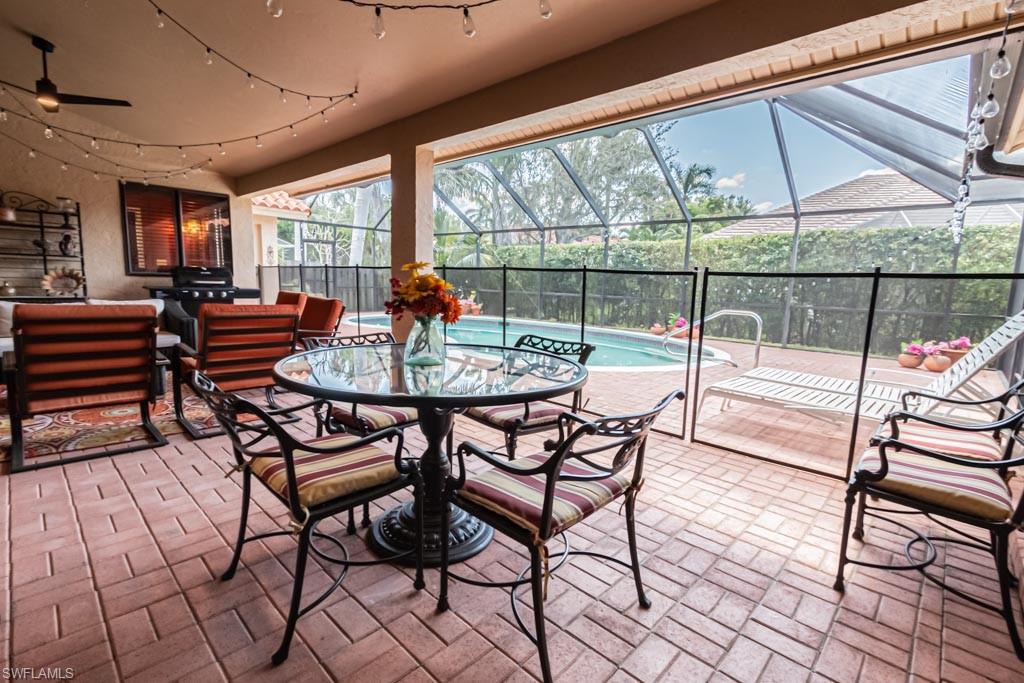 2209 Pinewoods Circle Naples, FL 34105 - Photo 35 of 46 a dining room with furniture and a floor to ceiling window