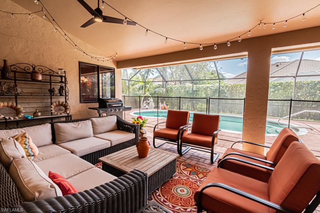 2209 Pinewoods Circle Naples, FL 34105 - Photo 38 of 46 a living room with furniture a flat screen tv and a large window