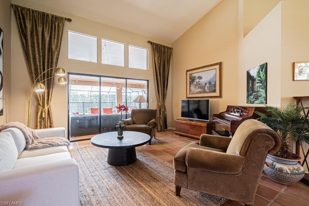 2209 Pinewoods Circle Naples, FL 34105 - Photo 6 of 46 a living room with furniture a fireplace and a large window