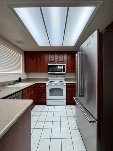 a kitchen with a refrigerator sink and cabinets