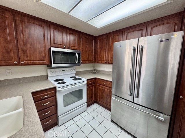 42140 Lyndie Lane, Unit 24 Temecula, CA 92591 - Photo 13 of 35 a kitchen with stainless steel appliances granite countertop a refrigerator stove a sink and dishwasher