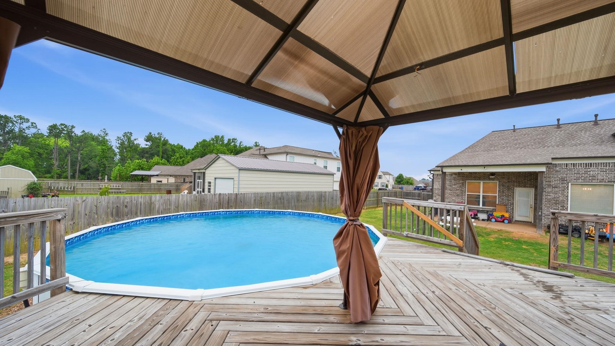 70 Trinity Cove Atoka, TN 38004 - Photo 24 of 25 Expansive wood deck with a built-in gazebo, featuring an above-ground pool