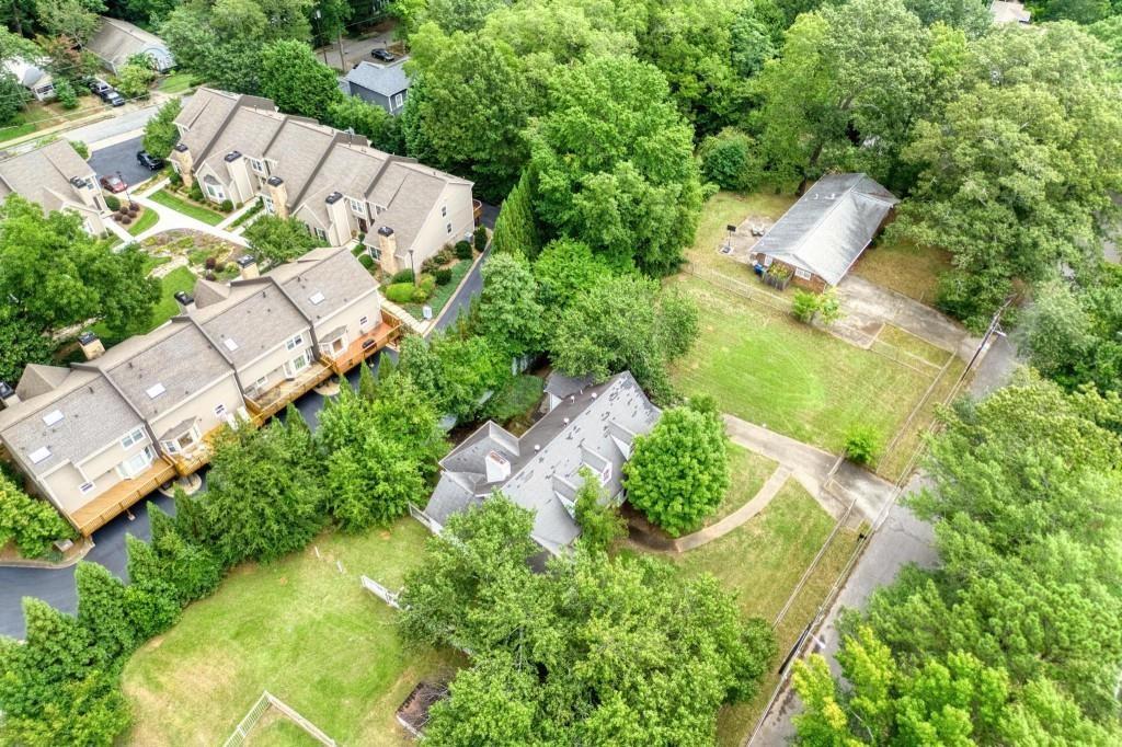 an aerial view of residential house with outdoor space and trees all around
