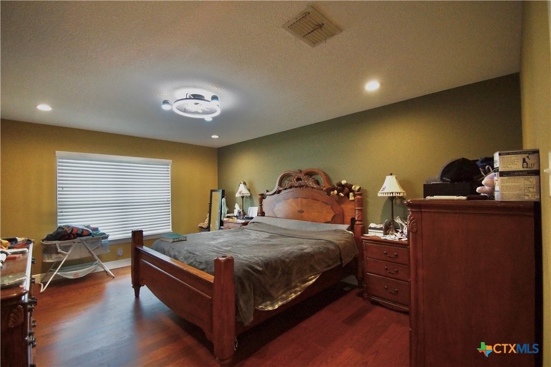 27 Stehle Road Victoria, TX 77905 - Photo 23 of 34 a bedroom with a bed and a chandelier