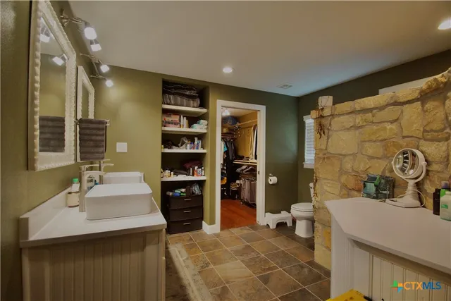 a bathroom with a double vanity sink toilet and shower