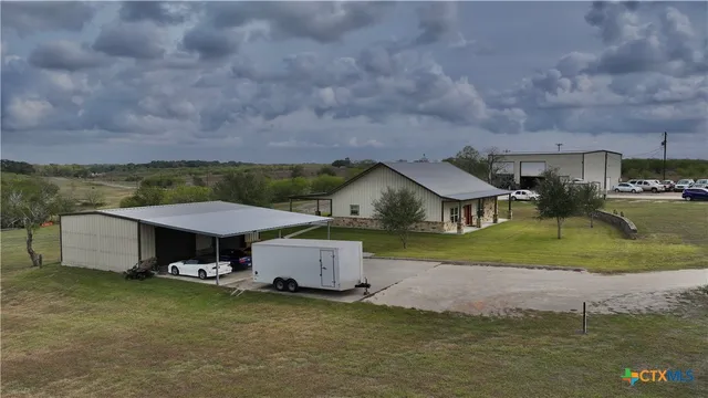 an aerial view of a house with swimming pool and a yard