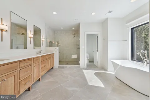 a spacious bathroom with a mirror a shower and a bathtub