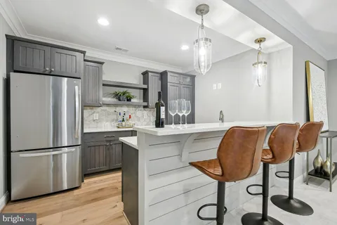 a kitchen with stainless steel appliances granite countertop a refrigerator a sink dishwasher a stove and a refrigerator with wooden floor