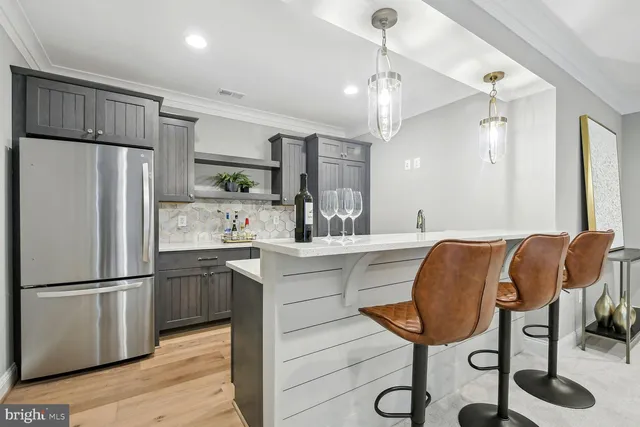 a kitchen with stainless steel appliances granite countertop a refrigerator a sink dishwasher a stove and a refrigerator with wooden floor