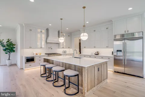 a large kitchen with kitchen island a stove a table and chairs