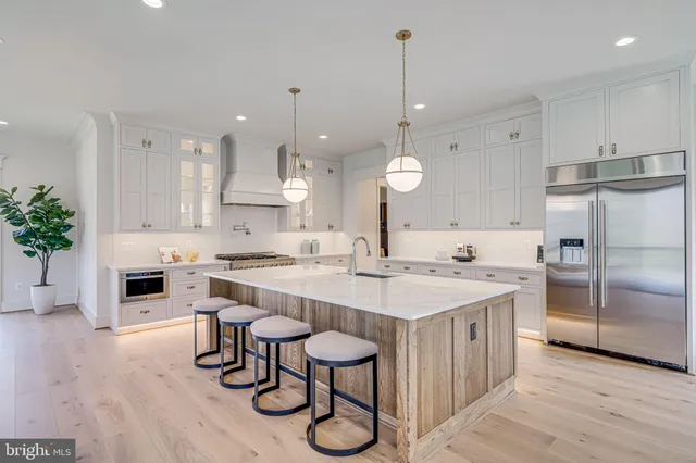 a large kitchen with kitchen island a stove a table and chairs