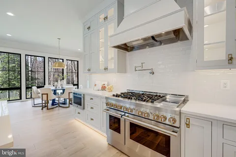 a kitchen with a stove a cabinets and wooden floor