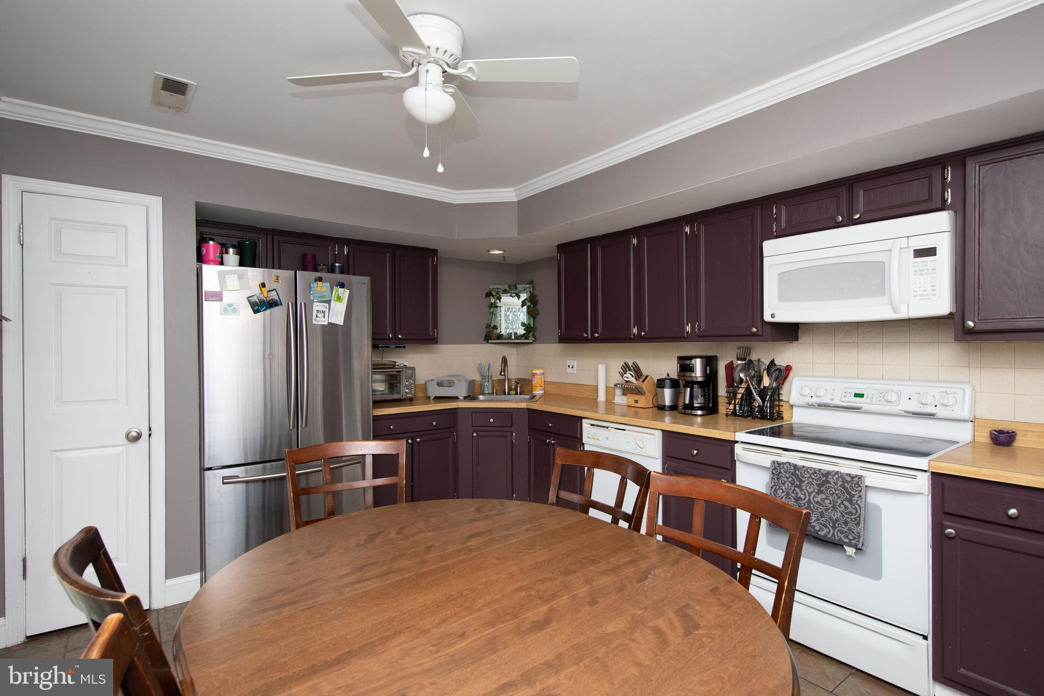 2086 Fort Bevon Road Harleysville, PA 19438 - Photo 10 of 24 a kitchen with stainless steel appliances granite countertop a refrigerator a sink dishwasher a stove a dining table and chairs with wooden floor