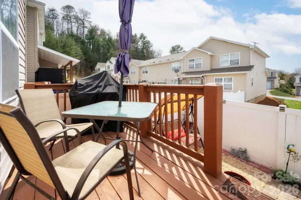 a view of a patio with table and chairs with wooden floor and fence