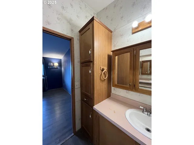 an empty room with wooden floor closet and windows