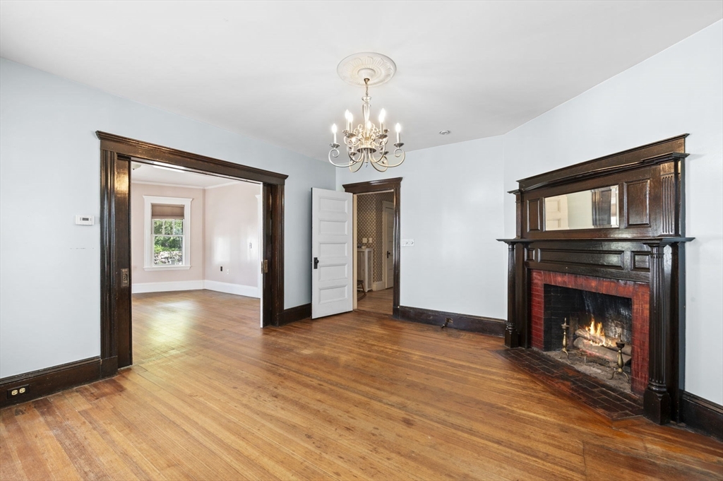 366 Cabot Street Beverly, MA 01915 - Photo 16 of 42 a view of an empty room with wooden floor fireplace and a window