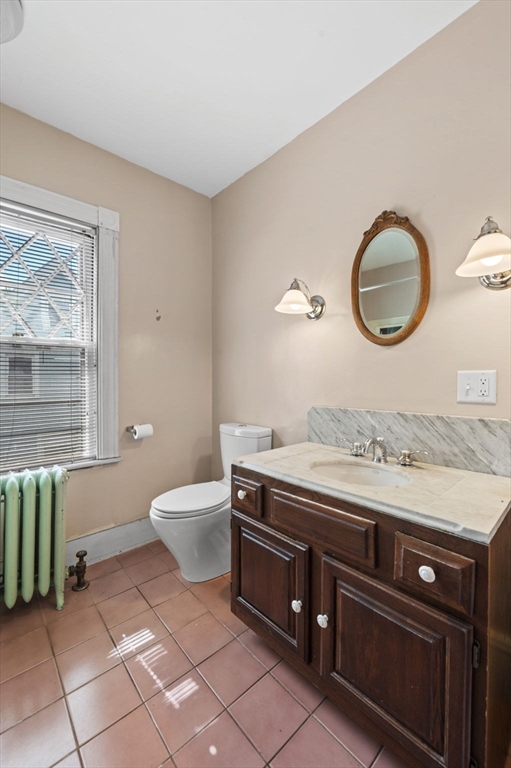 366 Cabot Street Beverly, MA 01915 - Photo 31 of 42 a bathroom with a granite countertop toilet a sink and mirror