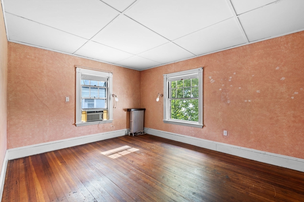 366 Cabot Street Beverly, MA 01915 - Photo 35 of 42 an empty room with wooden floor and windows