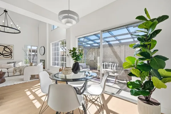 a dining room with furniture potted plants and wooden floor
