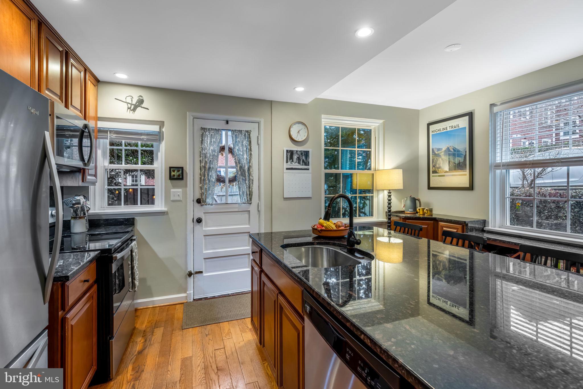 4225 32nd Road South Arlington, VA 22206 - Photo 17 of 36 a kitchen with stainless steel appliances granite countertop a stove top oven a sink dishwasher a refrigerator and cabinets with wooden floor